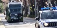 Il passaggio del lungo filobus sulla strada parco preceduto dall'auto della polizia